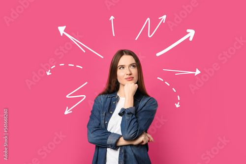 Choice in profession or other areas of life, concept. Making decision, thoughtful young woman surrounded by drawn arrows on pink background © New Africa