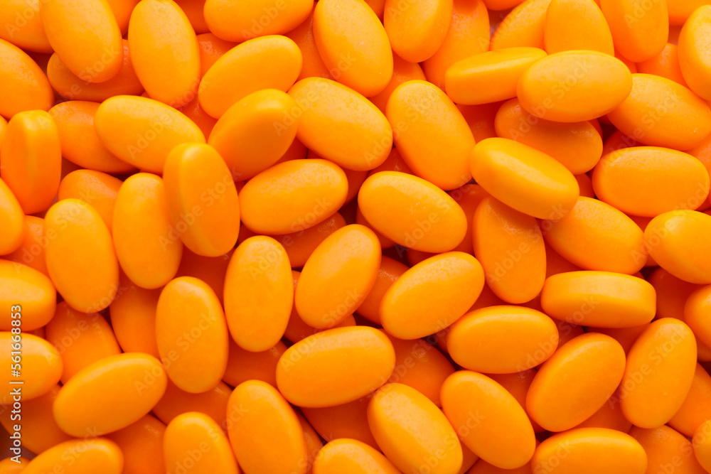 Tasty orange dragee candies as background, top view Tasty orange dragee candies as background, top view