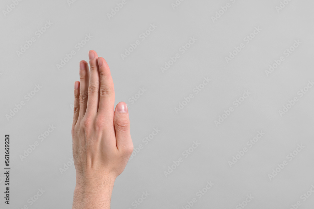 Man giving high five on grey background, closeup of hand. Space for text Man giving high five on grey background, closeup of hand. Space for text