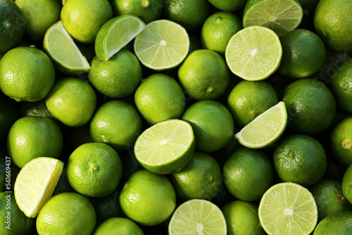 Whole and cut fresh ripe green limes as background, top view © New Africa