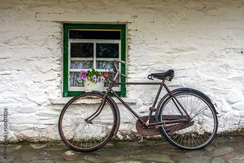 Traditional Irish scene with the old bike by the window of the thatch roof cottage