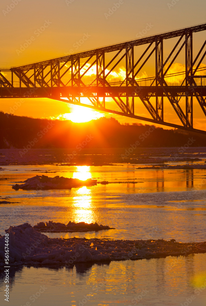 Fototapeta premium Sun setting behind Quebec City's Old Bridge.