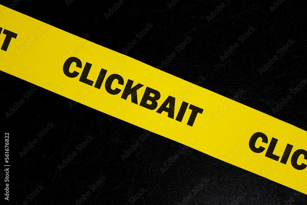 Clickbait scam alert, caution and warning concept. Yellow barricade tape with word clickbait in dark black background.