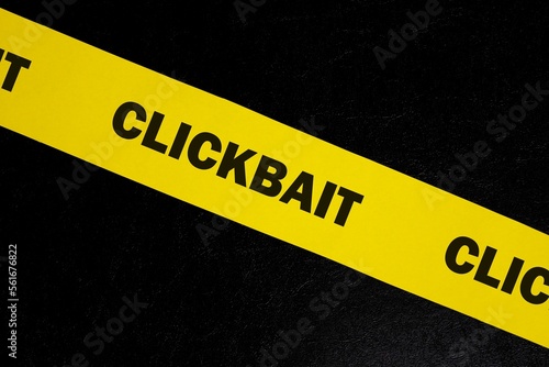 Obraz na płótnie Clickbait scam alert, caution and warning concept. Yellow barricade tape with word clickbait in dark black background. w salonie