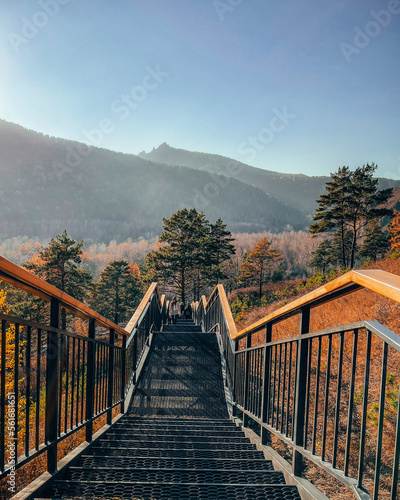Fototapeta An iron staircase leading to an observation deck in the mountains on a clear sunny day