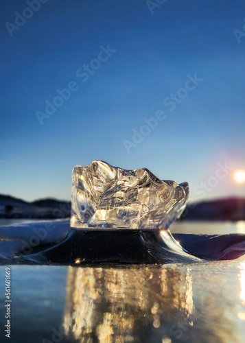 Beautiful ice on Lake Baikal on a clear winter day. Transparent ice block on Lake Baikal. Ice floe and sun on winter Lake Baikal. beautiful ice on a frozen lake on a sunny day. Selective focus.