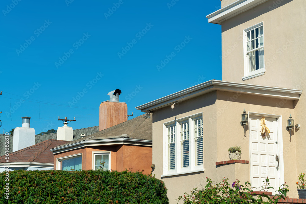 Fototapeta premium Row of house detail facades with front or back door visible on brown stuco house with white accents and orange building