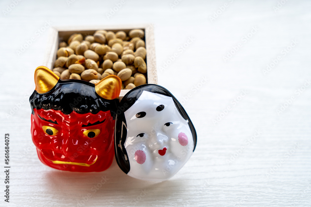 節分の豆まき用の豆と鬼とおたふくのお面（コピースペースあり）