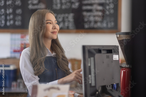 Opening a small business, A Happy Asian woman in an apron standing near a bar counter coffee shop, Small business owner, restaurant, barista, cafe, Online, SME, entrepreneur, and seller concept