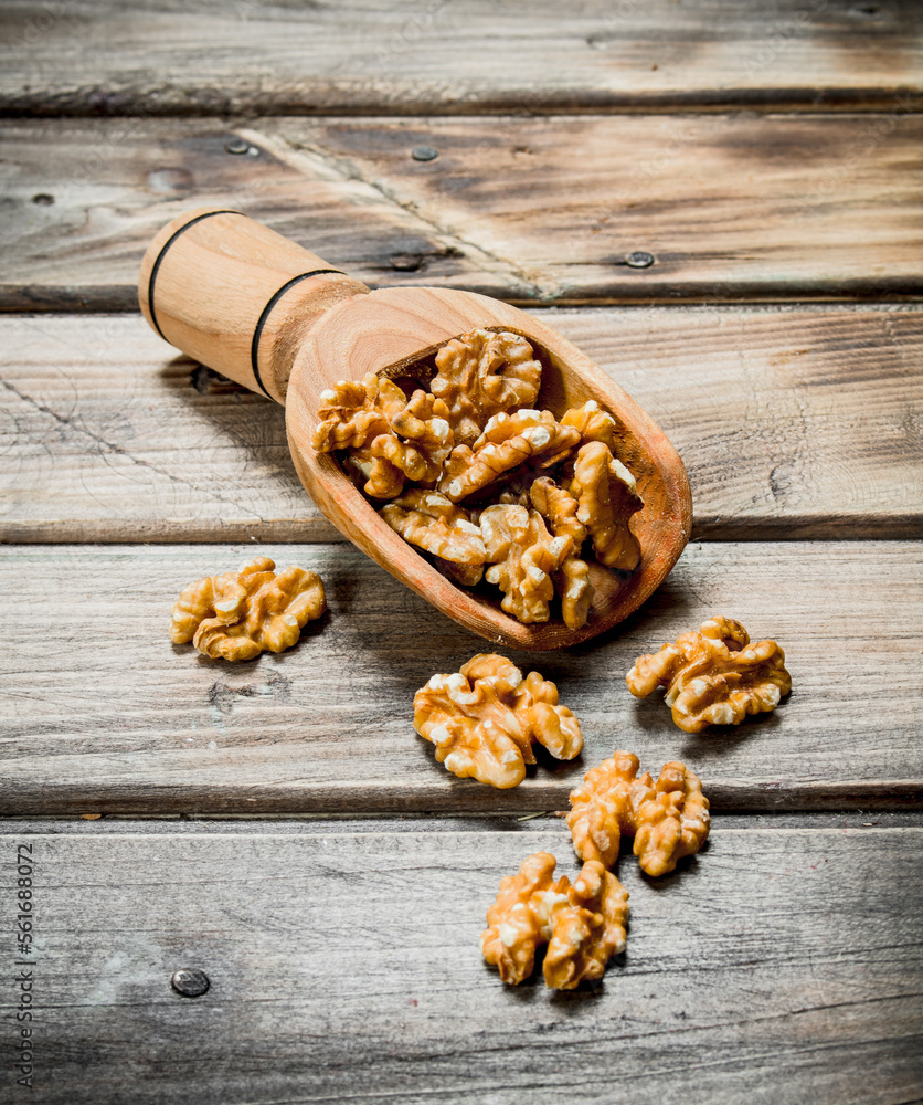 Peeled walnut in a wooden scoop . Peeled walnut in a wooden scoop .