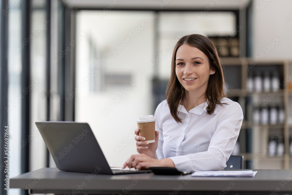 Portrait confident businesswoman working on laptop at her workplace at modern office. Portrait confident businesswoman working on laptop at her workplace at modern office.