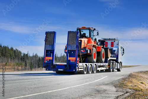 White Semi Truck Transports Wheel Loader, Rear View. Copy Space. 