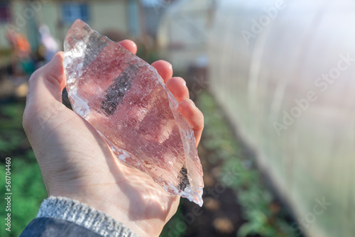 Fotografie Piece of ice in the hand of a man in the garden