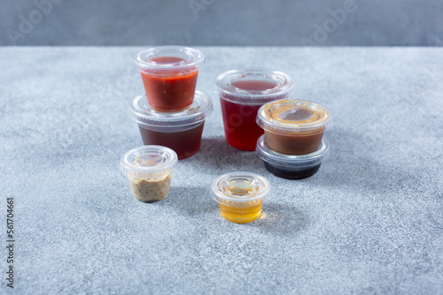 Φωτογραφία A view of several varieties of plastic condiment cups.