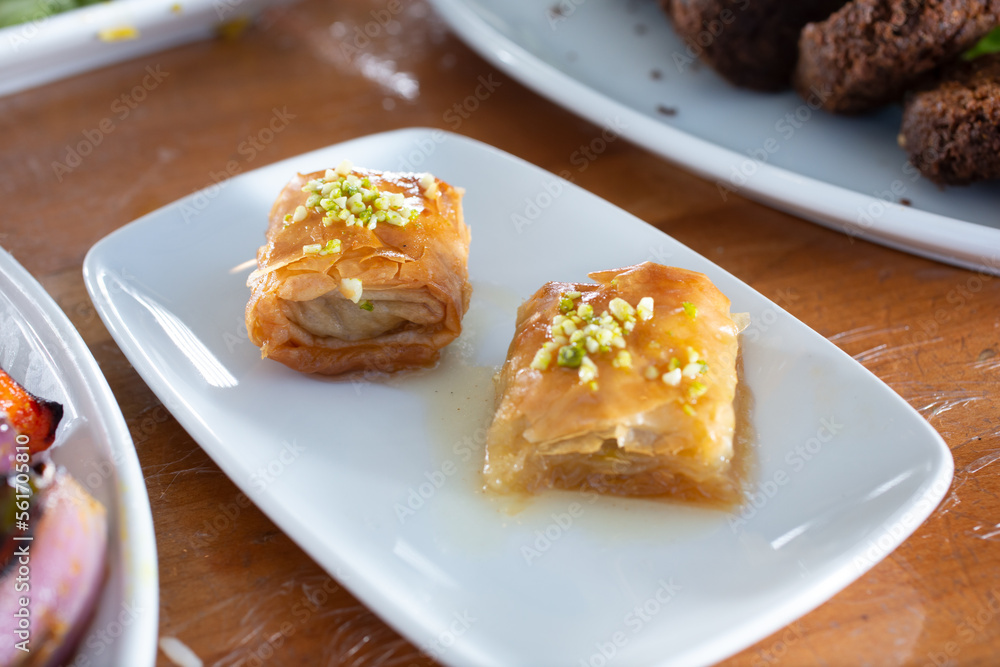 A view of a plate of baklava pieces.