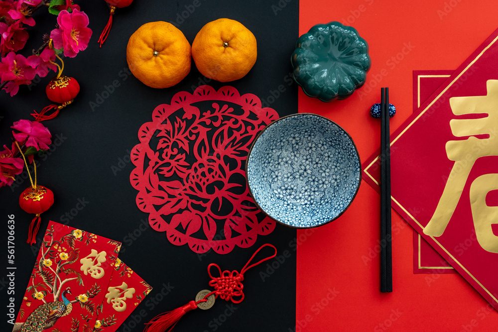 Chinese lunar new year decoration over red and black background. Flat lay dinning table concept with festive decoration. Translation for word on decoration mean “blessing” and Chinese lunar new year decoration over red and black background. Flat lay dinning table concept with festive decoration. Translation for word on decoration mean “blessing” and