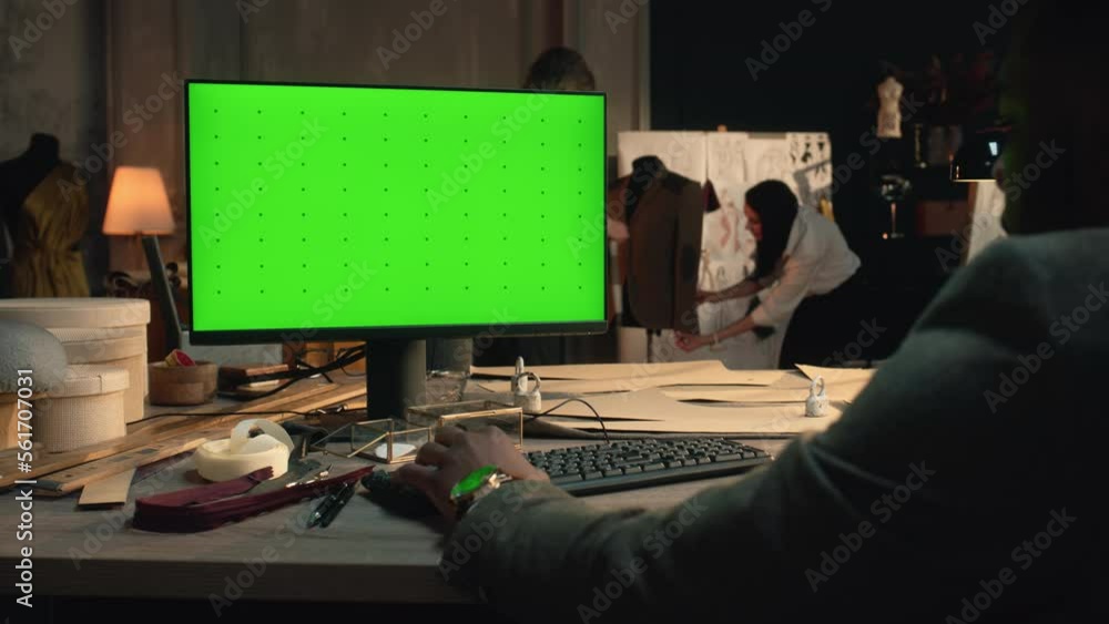 African American tailor or fashion designer creates and developes clothes on computer with green screen in luxury atelier or tailoring workshop. Man sits on workplace and types on keyboard. Chromakey. African American tailor or fashion designer creates and developes clothes on computer with green screen in luxury atelier or tailoring workshop. Man sits on workplace and types on keyboard. Chromakey.