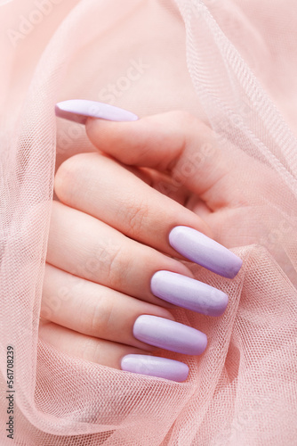 Girl s hands with a soft purple manicure.