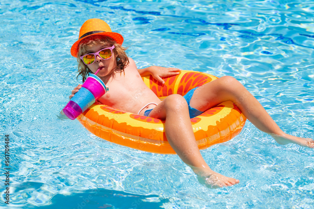 Kid boy in swimming pool on inflatable ring. Children swim with orange float. Water toy, healthy outdoor sport activity for children. Kids beach fun.
