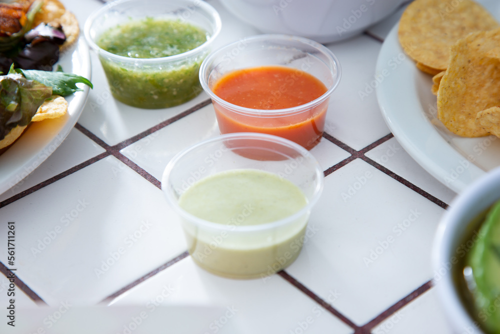 A view of a variety of salsas in plastic condiment cups. A view of a variety of salsas in plastic condiment cups.