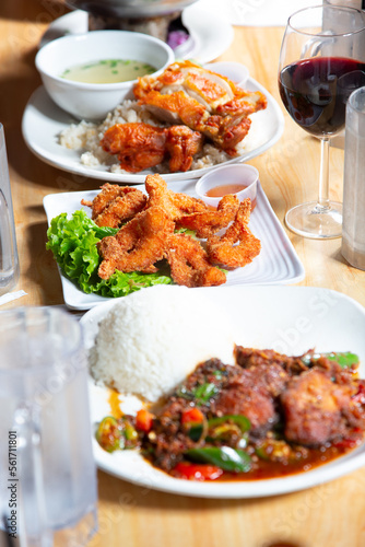 A view of several pan Asian entrees, featuring crispy Hainan chicken, coconut shrimp, and spicy chili beef.