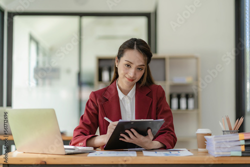 Asian businesswoman working with laptop computer and calculator financial documents on table make a plan analyzing financial reports business plan investment in the office