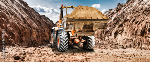Bulldozer or loader at a construction site in a quarry transporting sand. Powerful wheel loader or bulldozer with a large bucket at a construction site. Construction equipment for earthworks.