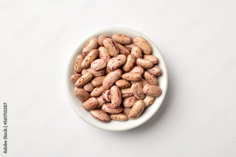 Uncooked pinto beans in bowl on white background Uncooked pinto beans in bowl on white background