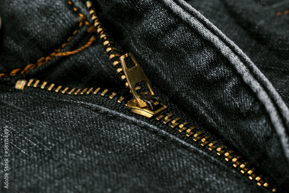 Naklejka premium Closeup of zipper in blue jeans. Zipper with lock. A piece of denim