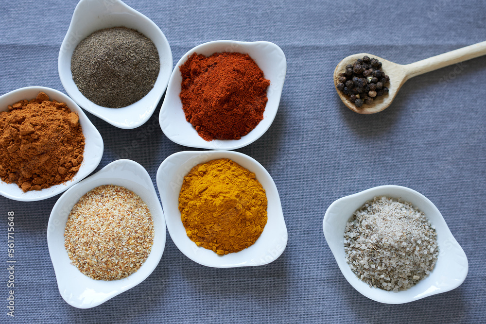 Spices close-up on a gray background. Black pepper, bell pepper, chili pepper, garlic, curcumin, pea pepper and salt and spice. Spices close-up on a gray background. Black pepper, bell pepper, chili pepper, garlic, curcumin, pea pepper and salt and spice.