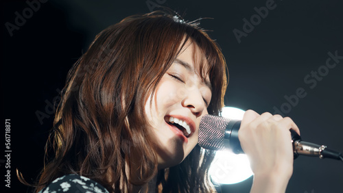 Fotografía スポットライトを浴びて歌う女性　ライブ　コンサート　カラオケ