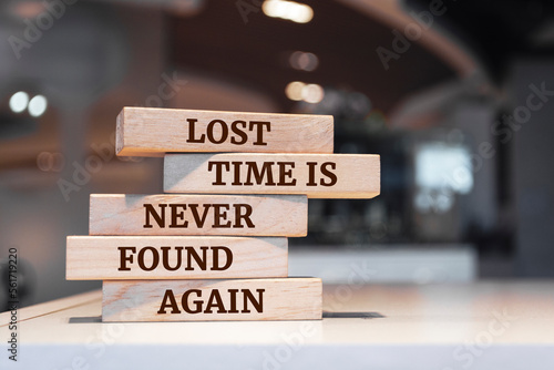 Wooden blocks with words 'Lost time is never found again'.