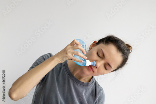 Foto Girl rinses her nose with saline solution at home Using Neti Pot