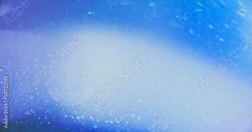Defocused glow overlay. Bokeh light. Shimmering gleam. Blur white blue color lens flare shiny glitter texture abstract empty space background.