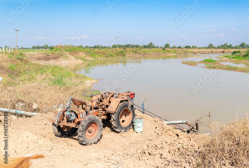 Tractor pumping water from a canal to the rice field.