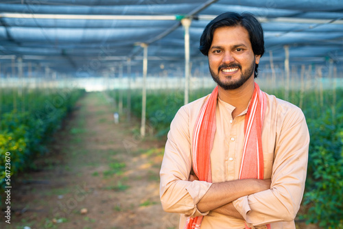 Obraz na plátne happy young farmer confidently smiling by looking at greenhouse - concept of ent