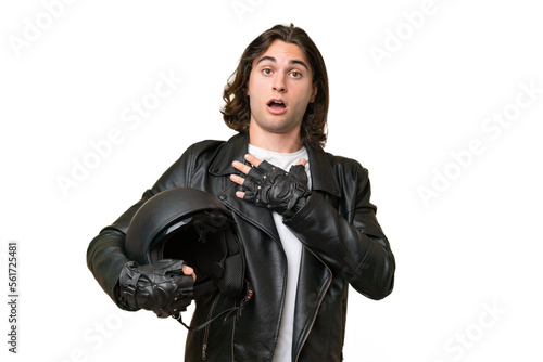 Young handsome man with a motorcycle helmet isolated on green chroma background surprised and shocked while looking right