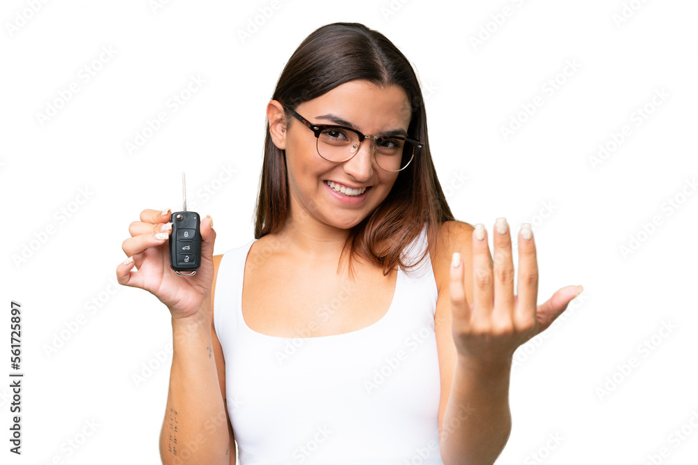 Young caucasian woman holding car keys isolated on green chroma background background inviting to come with hand. Happy that you came Young caucasian woman holding car keys isolated on green chroma background background inviting to come with hand. Happy that you came