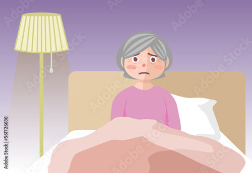 夜、ベッドの中で眠れずにボーッとしている高齢女性
