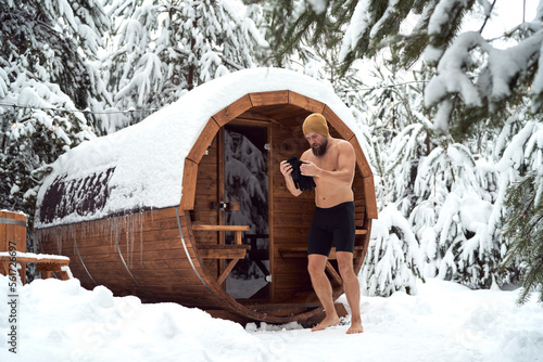 Caucasian man wearing gloves and going into the winter swim outdoors photo