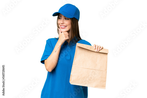 Young beautiful caucasian woman taking a bag of takeaway food over isolated background looking to the side and smiling