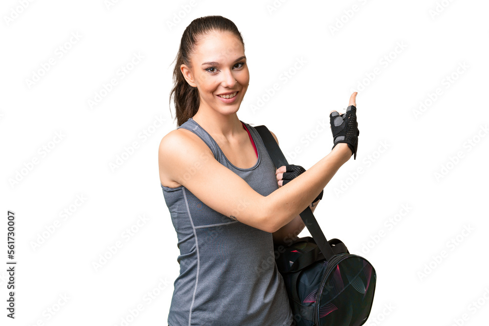 Young sport woman with sport bag over isolated background pointing back Young sport woman with sport bag over isolated background pointing back