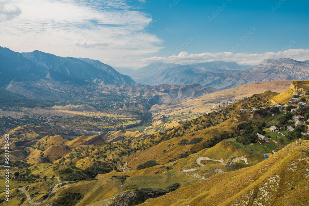 Snow-capped mountains and autumn fields. Beautiful mountain landscape in winter. Panoramic view, Dagestan, Russia.