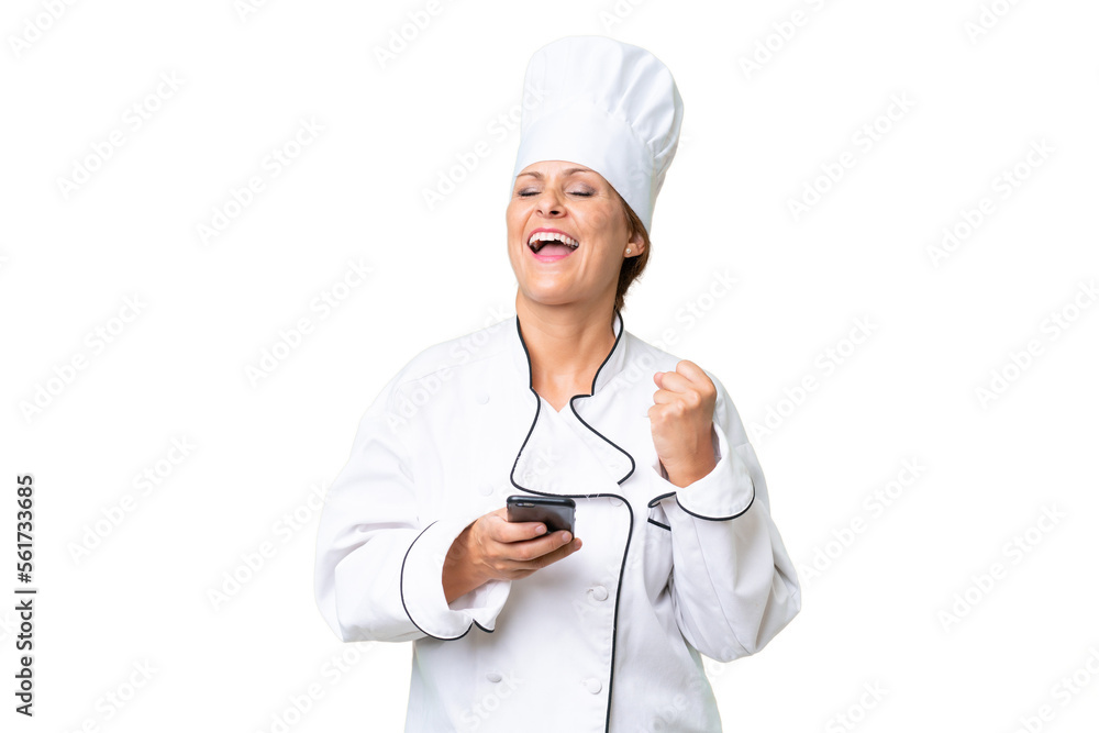 Middle-aged chef woman over isolated background with phone in victory position Middle-aged chef woman over isolated background with phone in victory position