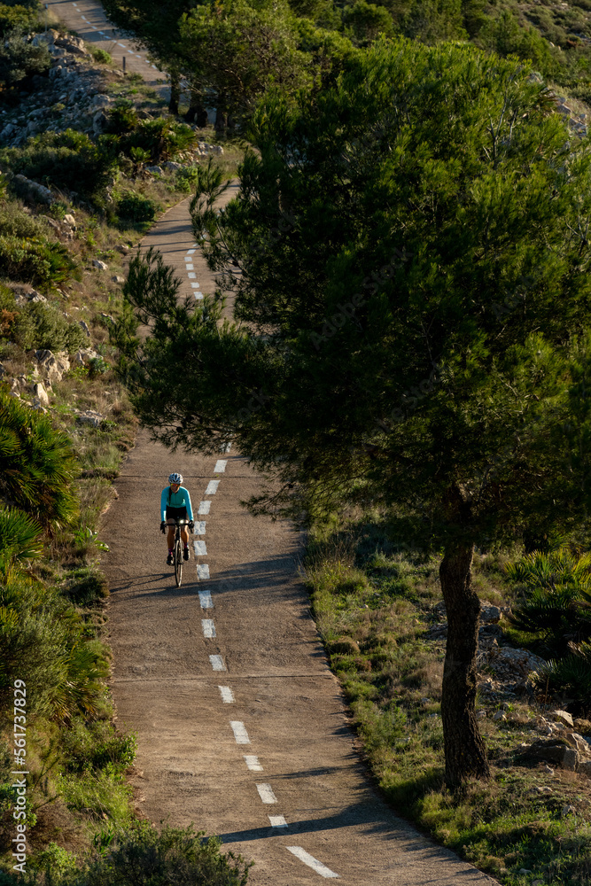 Mature cyclist riding bicycle on mountain road Mature cyclist riding bicycle on mountain road