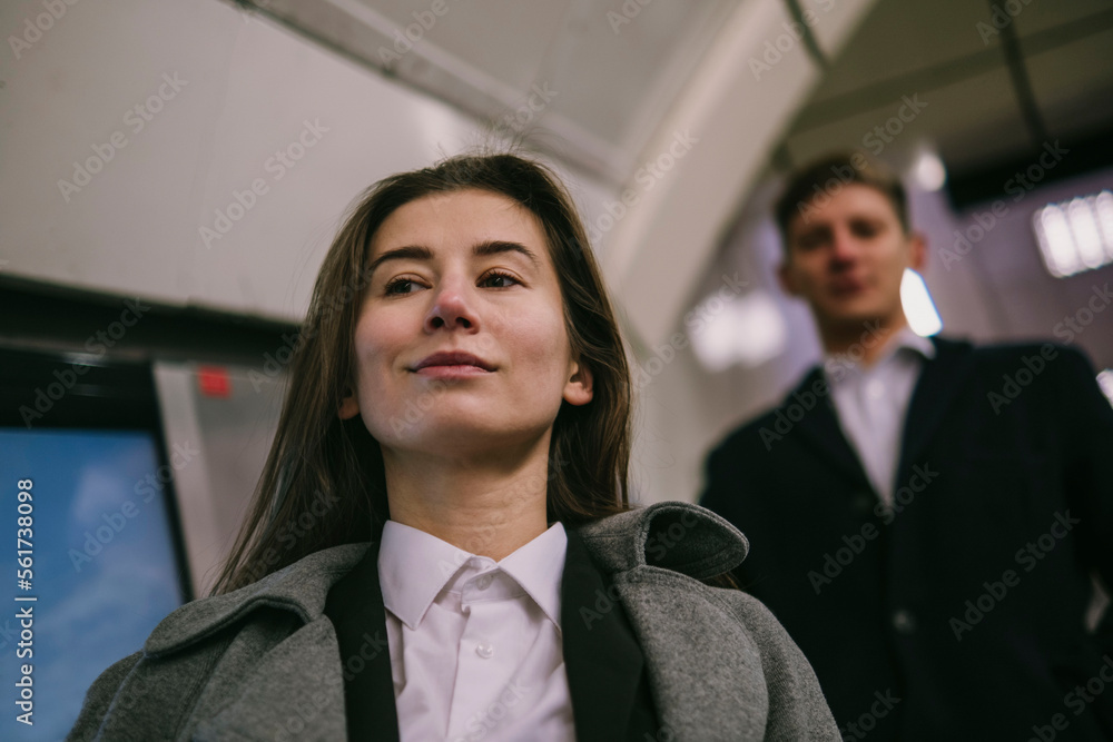 Smiling businesswoman standing with colleague at station Smiling businesswoman standing with colleague at station