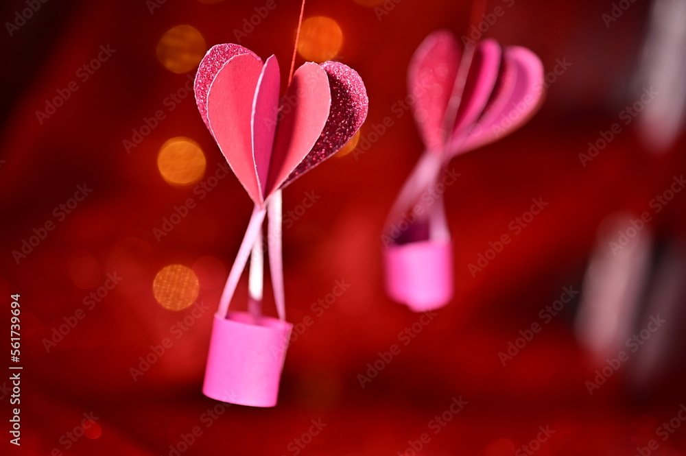 Fototapeta premium Love travels. Paper craft pink heart shaped hot air balloons traveling through the air on a shiny background. Concept for Valentine's Day, Mother's Day, wedding greeting card. Romantic background.