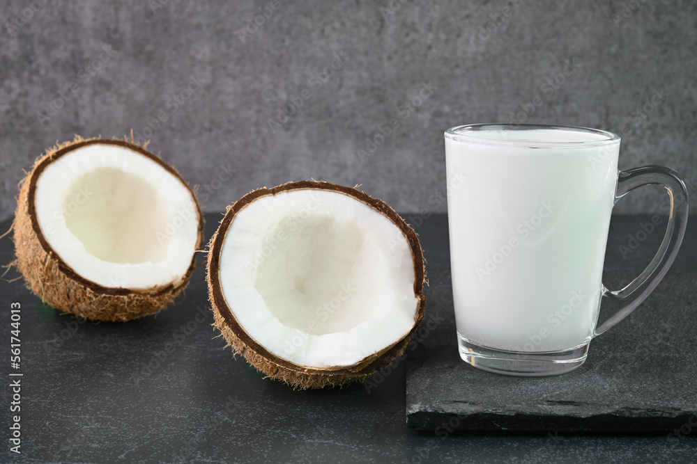 Coconut milk in a glass cup with coconuts in the background. Coconut milk in a glass cup with coconuts in the background.