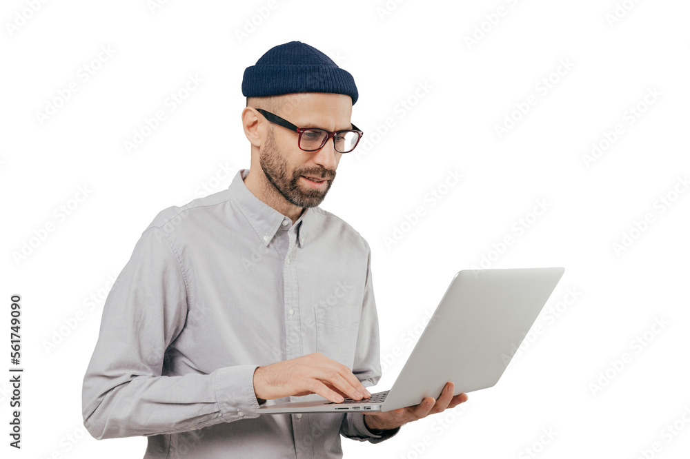 Professional IT developer downloads files, chats online in social networks, bloggs and surfes internet webpages wears formal shirt, stands against grey background. Technology and people concept Professional IT developer downloads files, chats online in social networks, bloggs and surfes internet webpages wears formal shirt, stands against grey background. Technology and people concept