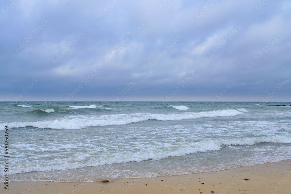 Rolling waves on sandy beach Baltic Sea.